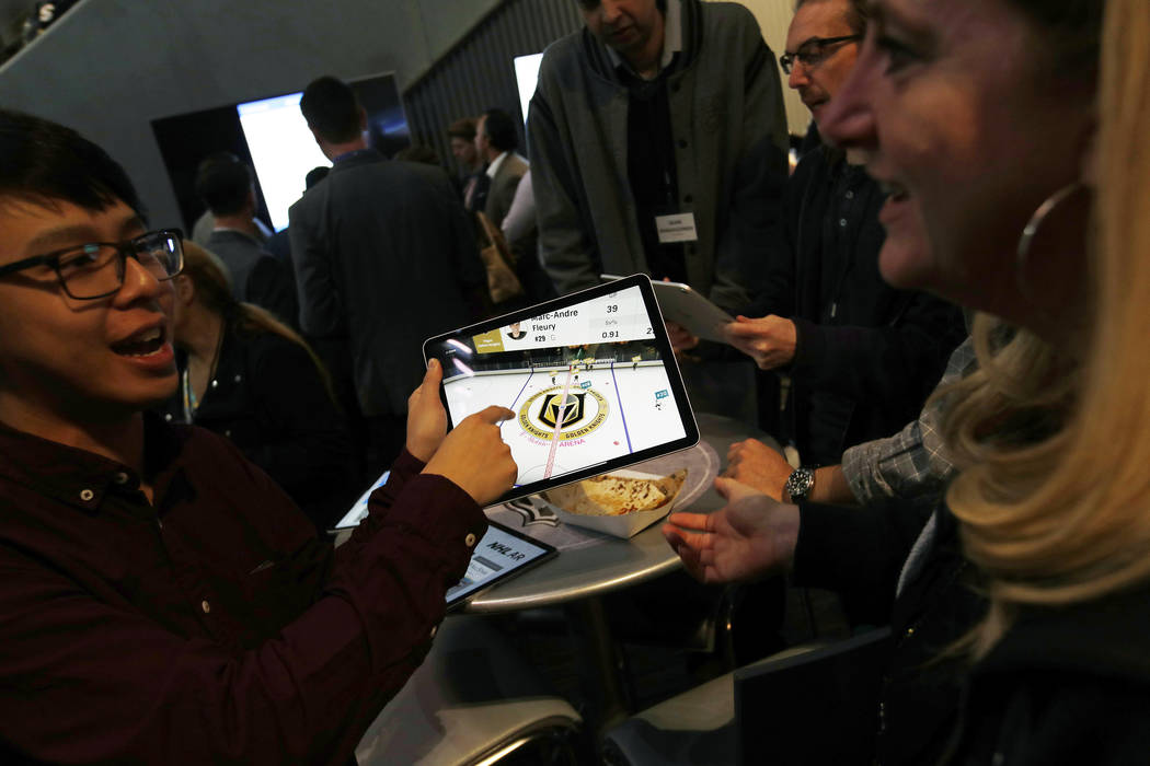People watch real-time puck and player tracking technology on a tablet during an NHL hockey game between the Vegas Golden Knights and the San Jose Sharks in Las Vegas, Thursday, jan. 10, 2019. The ...