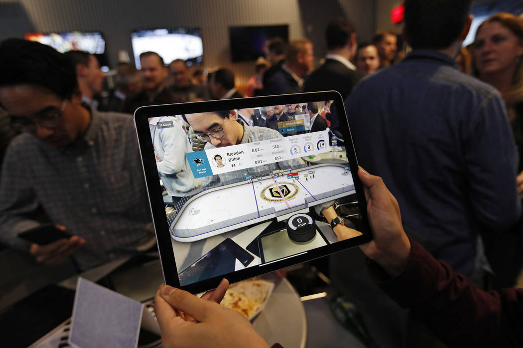 People watch real-time puck and player tracking technology on display during an NHL hockey game between the Vegas Golden Knights and the San Jose Sharks in Las Vegas, Thursday, Jan. 9, 2010. The N ...