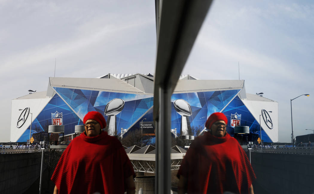 Mercedes-Benz Stadium is reflected in a window ahead of Sunday's NFL Super Bowl 53 football game between the Los Angeles Rams and New England Patriots in Atlanta, Friday, Feb. 1, 2019. (AP Photo/D ...