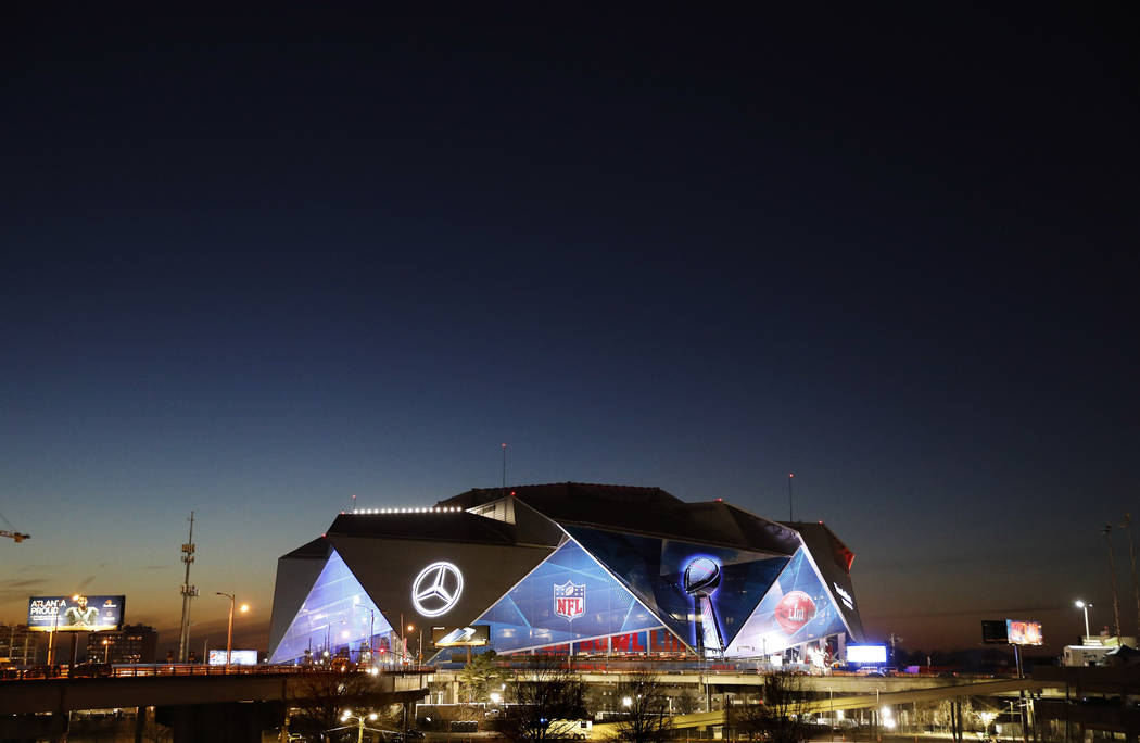 The sun sets behind Mercedes-Benz Stadium ahead of Sunday's NFL Super Bowl 53 football game between the Los Angeles Rams and New England Patriots in Atlanta, Wednesday, Jan. 30, 2019. (AP Photo/Da ...