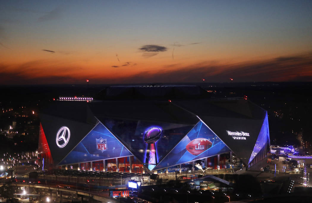 The sun sets behind Mercedes-Benz Stadium ahead of Sunday's NFL Super Bowl 53 football game between the Los Angeles Rams and New England Patriots in Atlanta, Wednesday, Jan. 30, 2019. (AP Photo/Da ...