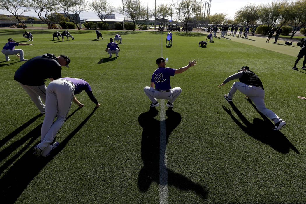 Members of the Colorado Rockies pitching staff warm up at their spring baseball training facility in Scottsdale, Ariz., Saturday, Feb. 16, 2019. (AP Photo/Chris Carlson)