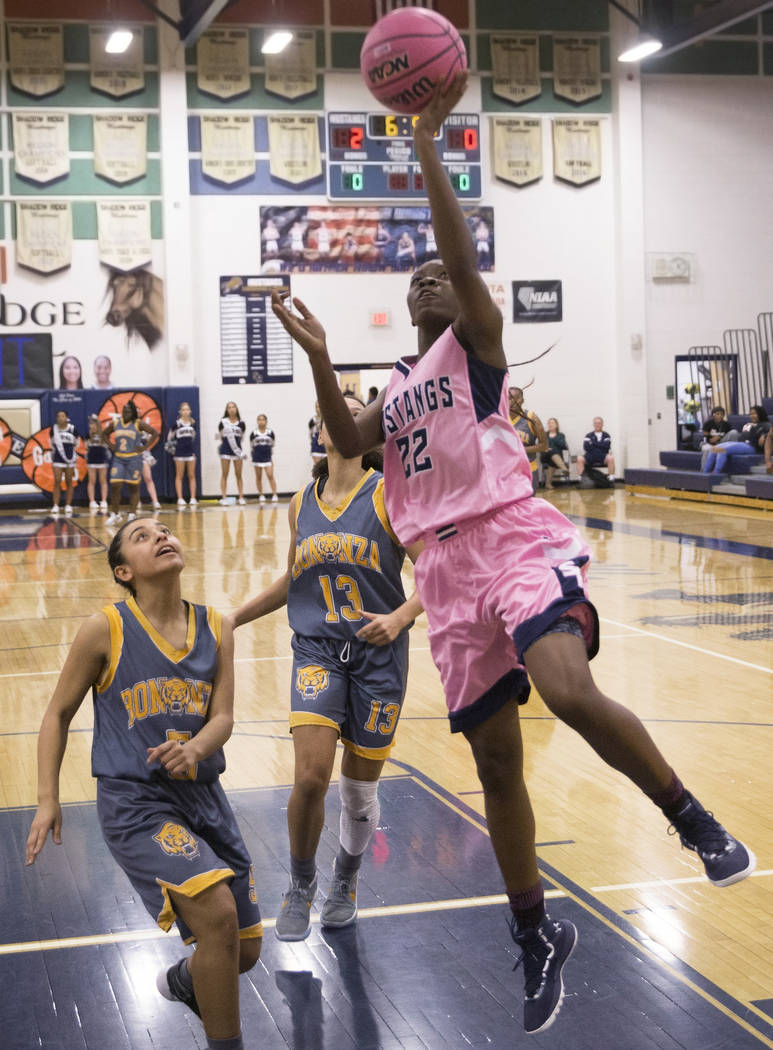 Shadow Ridge senior Vashay Young (22) converts a fast break layup over Bonanza senior Macyn Raleigh (13) and sophomore Isaira Diaz (5) in the first quarter on Monday, Feb. 4, 2019, at Shadow Ridge ...