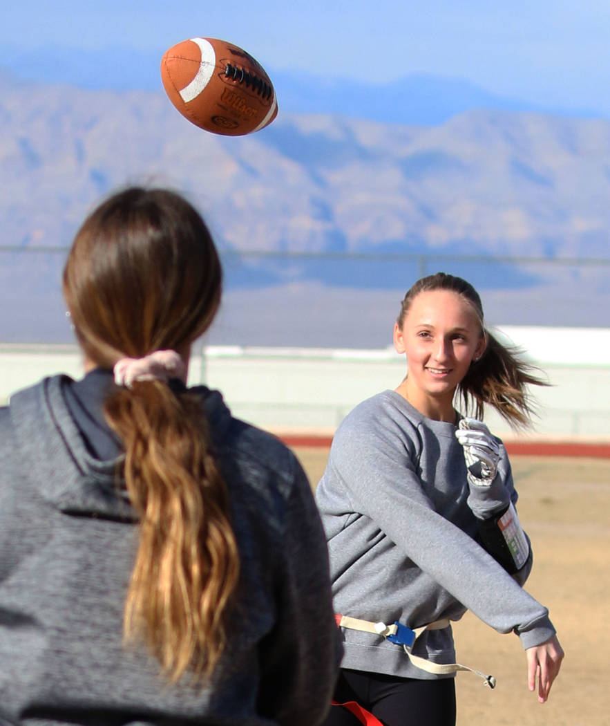 Coronado freshman flag football quarterback Ashtyn Almeido throws the ball to backup quarterback Kaylin Hall as they warm up during team practice on Wednesday, Feb. 6, 2019, at Coronado High Schoo ...