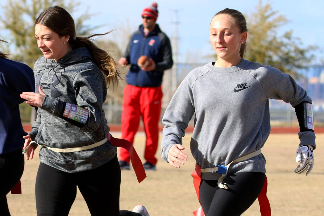 Coronado flag football quarterbacks Ashtyn Almeido, right, and Kaylin Hall, sprint as head coach Rusty Andersen, center, looks on during team practice on Wednesday, Feb. 6, 2019, at Coronado High ...
