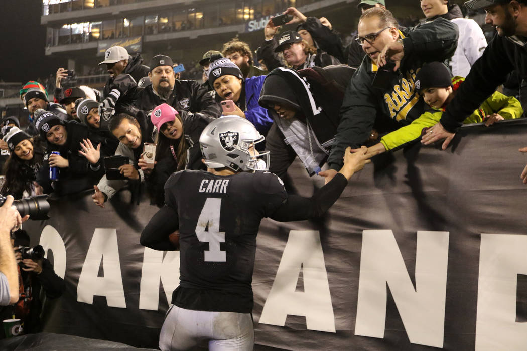 Oakland Raiders quarterback Derek Carr (4) meets with fans the Oakland-Alameda County Coliseum field after the team's win over the against the Denver Broncos in Oakland, Calif., Monday, Dec. 24, 2 ...