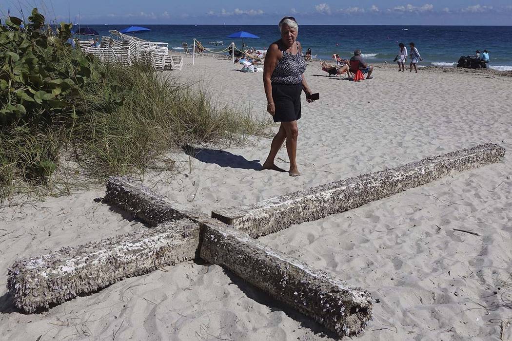 Aglair Rigos checks out the large, barnacle-covered wooden cross on the Galt Ocean Mile behind the Ocean Manor Beach Resort in Fort Lauderdale, Florida, on Tuesday, Feb. 5, 2019. (Joe Cavaretta/So ...