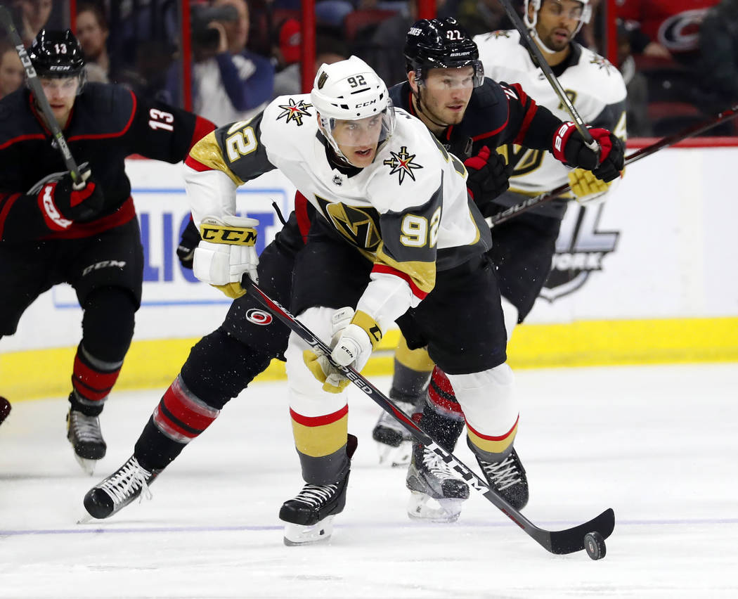 Vegas Golden Knights' Tomas Nosek (92) sakes with the puck after taking it from Carolina Hurricanes' Brett Pesce (22) during the first period of an NHL hockey game Friday, Feb. 1, 2019, in Raleigh ...