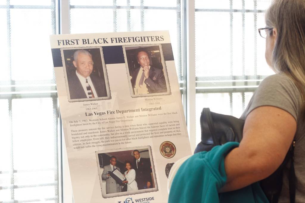 An attendee of the event observes a part of the History of Black Firefighters photo exhibit at the Doolittle Senior Center on a recent Saturday. (Mia Sims/Las Vegas Review-Journal @miasims___)
