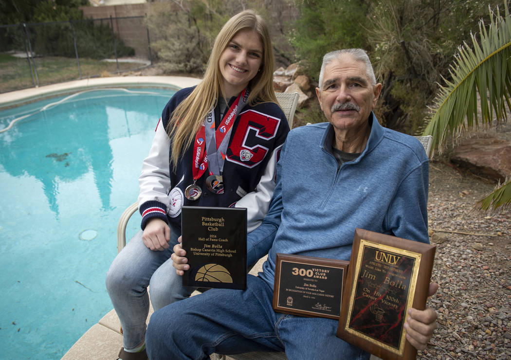 Sasha Bolla wears volleyball medals she has earned as she poses for a photograph with her father Jim Bolla, former UNlV women's basketball coach, as he holds plaques he has been awarded for his co ...