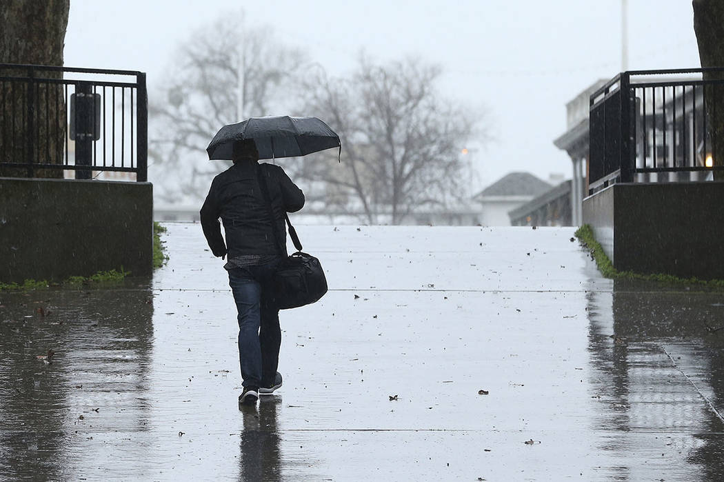 Umbrellas were put to use as a storm moved through Sacramento, Calif., Wednesday, Feb. 13, 2019. Rain is falling widely in Northern California and is expected to spread south.(AP Photo/Rich Pedron ...