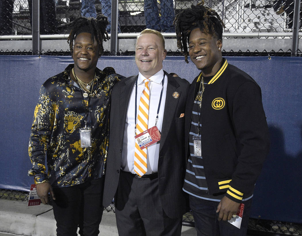 Orlando Apollos president Michael Waddell, center, poses on the sideline with Seattle Seahawks linebacker Shaquem Griffin, left, and defensive back Shaquill Griffin during the first half of the te ...