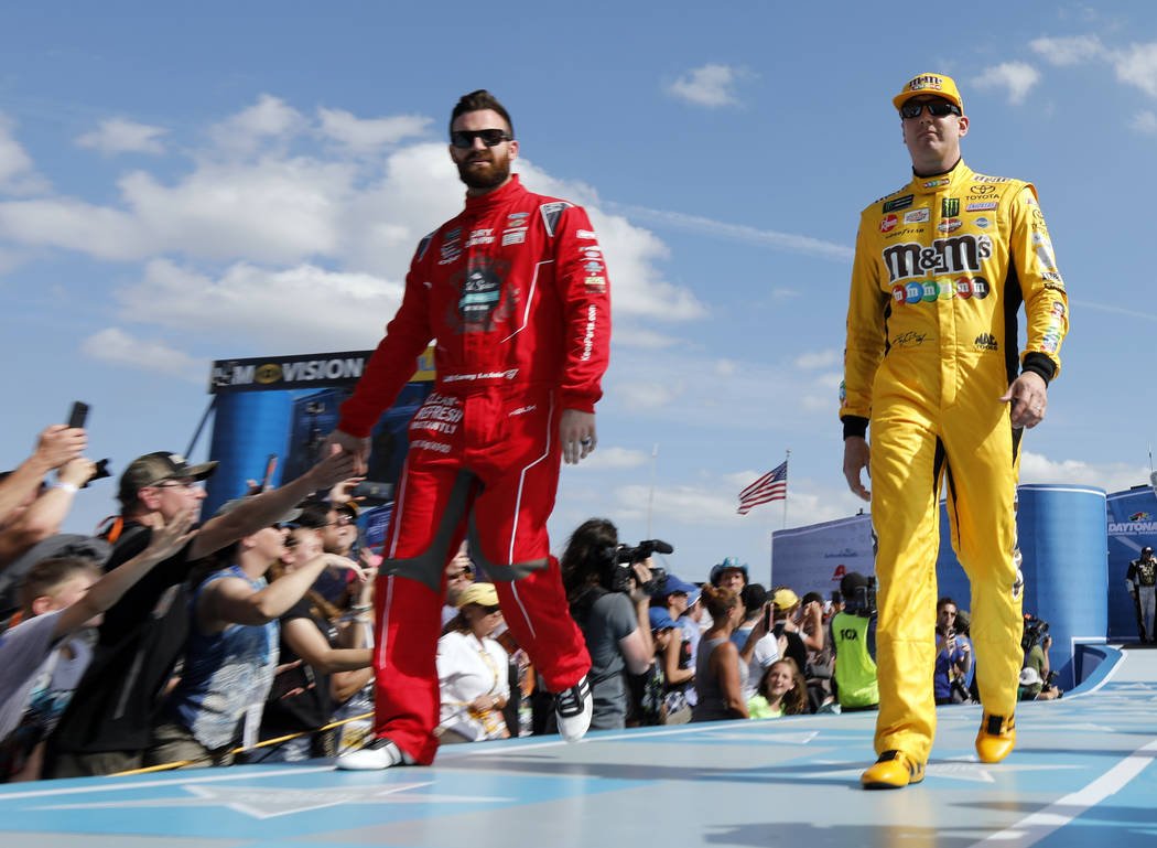 Corey LaJoie, front left, and Kyle Busch greet fans during driver introductions before the NASCAR Daytona 500 auto race at Daytona International Speedway, Sunday, Feb. 17, 2019, in Daytona Beach, ...
