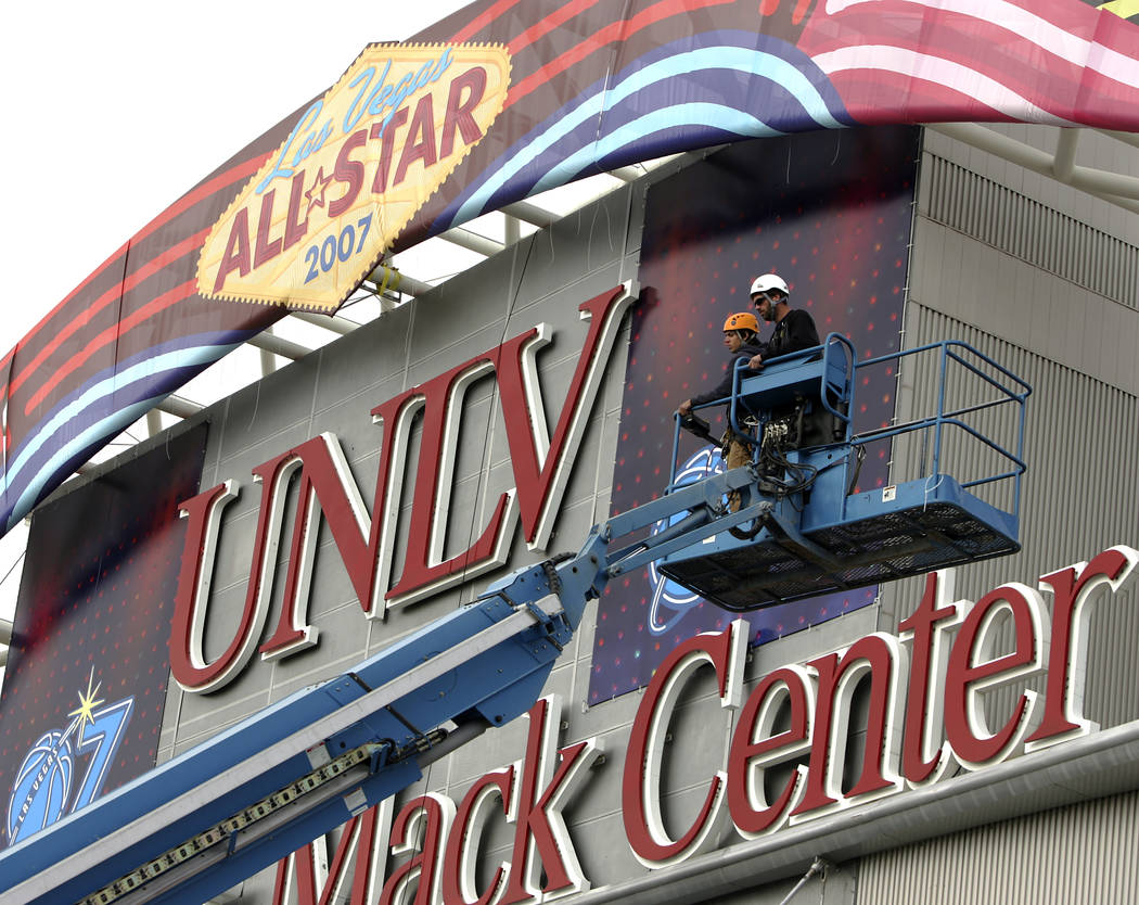Workers finish installing banners at the Thomas and Mack Center in preparation for the NBA All-Star game this weekend. (John Gurzinski/Las Vegas Review-Journal)