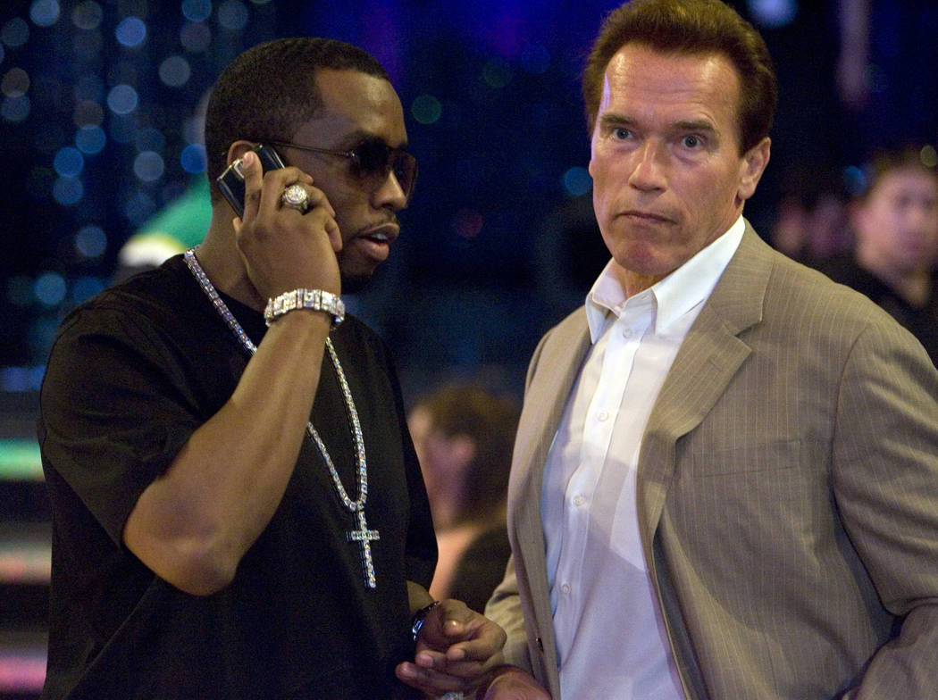Sean "P. Diddy" Combs, left, takes a call while chatting with California Gov. Arnold Schwartzeneger before the start of the NBA All-Star Game at the Thomas & Mack Center Sunday, Feb. 18, 2007. K. ...