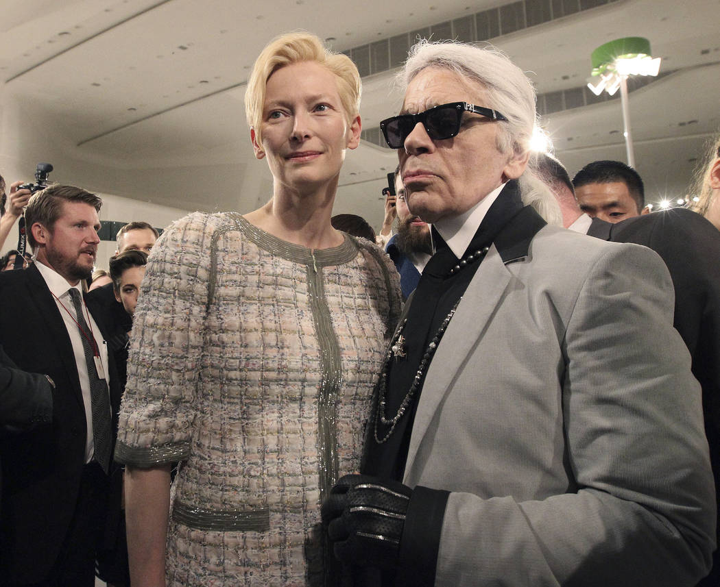FILE - In this Monday, May 4, 2015 file photo, Karl Lagerfeld, right, poses with British actress Tilda Swinton after the presentation of his 2015-2016 Chanel cruise collection at the Dongdaemun De ...