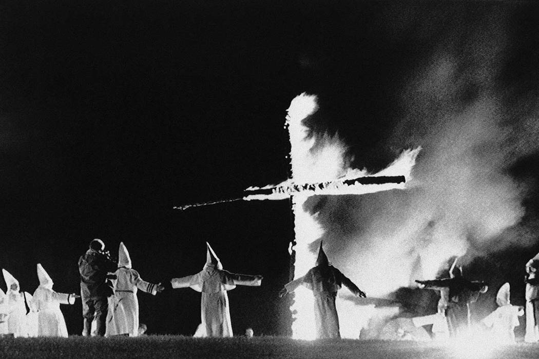 In this Sept. 27, 1987, file photo, the Invisible Empire, Ku Klux Klan members wearing traditional robes form a circle around a burning cross in Rumford, Maine. The pubisher of an Alabama weekly n ...