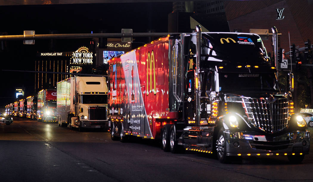 Fans watch hauler trucks during their annual parade up the Las Vegas Strip to kick off NASCAR festivities. (David Becker/Las Vegas Review-Journal)