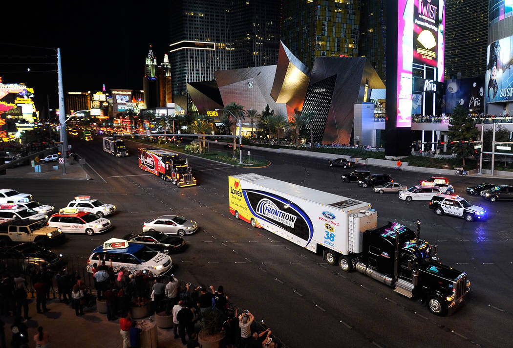 Fans watch hauler trucks during their annual parade up the Las Vegas Strip to kick off NASCAR festivities. (David Becker/Las Vegas Review-Journal)