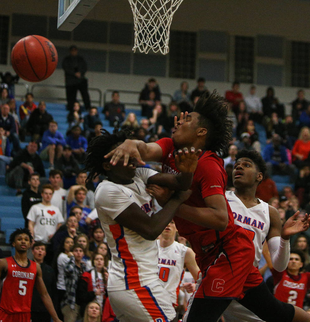 Bishop Gorman's Will McClendon (1) swats the ball out of the hands of Coronado's Jhaylon Martinez (33) during the Desert Region boys semifinal game at Foothill High Schoo in Henderson, Tuesday, Fe ...
