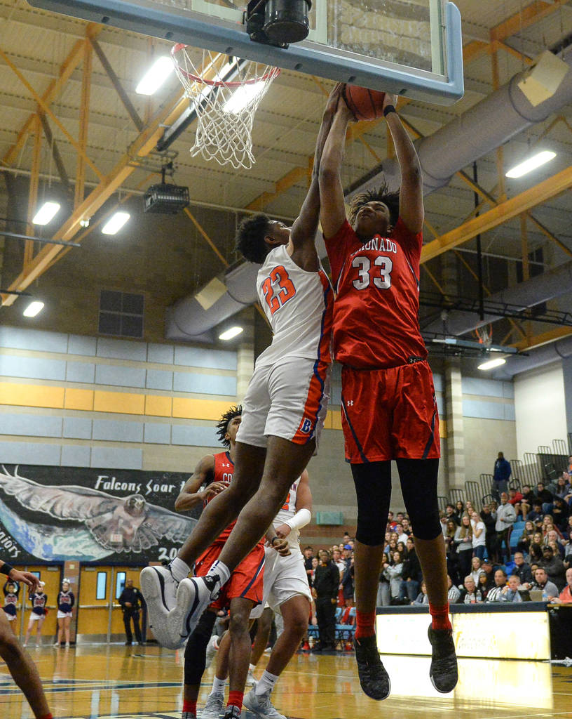 Coronado's Jhaylon Martinez (33) jumps up to take a shot while being guarded by Bishop Gorman's Mwani Wilkinson (23) during the Desert Region boys semifinal game at Foothill High Schoo in Henderso ...