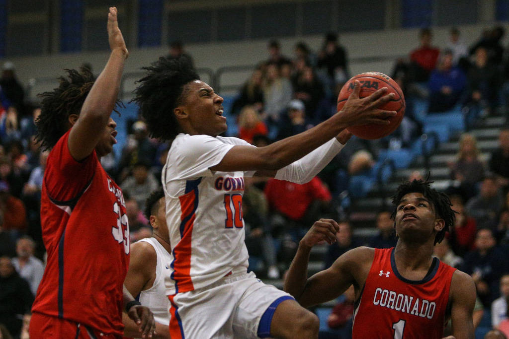 Bishop Gorman's Zaon Collins (10) jumps up to take a shot while being guarded by Coronado's Jhaylon Martinez (33) as Jaden Hardy (1) watches during the Desert Region boys semifinal game at Foothil ...
