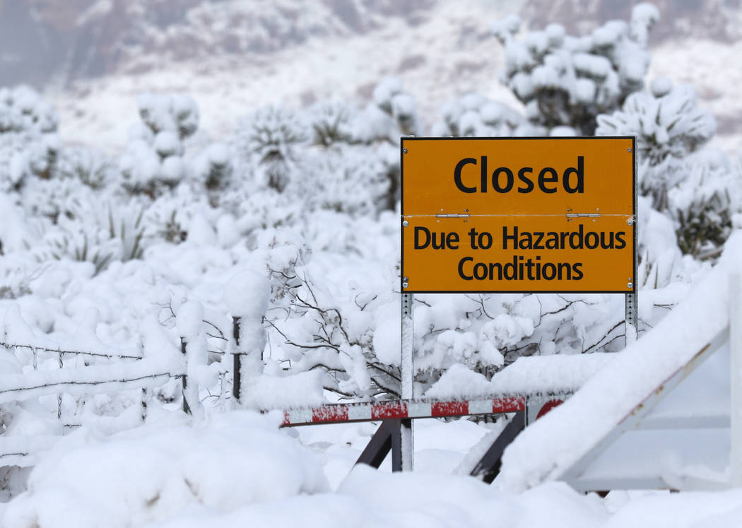 Signage is posted facing state Route 159 at the main entrance to Red Rock Canyon National Conservation Area outside Las Vegas to inform visitors that the park is closed due to snow fall in the are ...