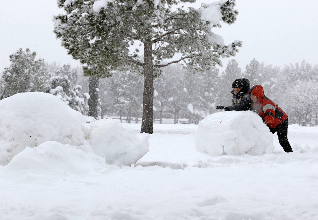 Cameron Partovi, right, and Sammy Kamyar build a snowman in South Tower Park in Summerlin as snow falls in Las Vegas, Thursday, Feb. 21, 2019. (Heidi Fang /Las Vegas Review-Journal) @HeidiFang