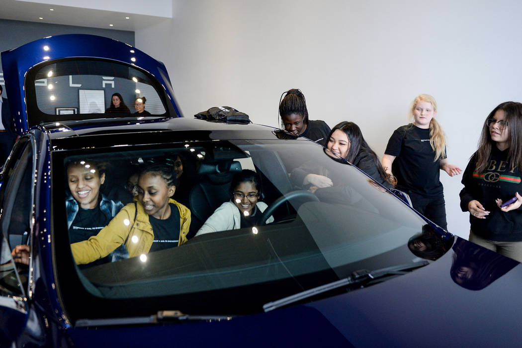Middle school students check out one of the Tesla cars on display as Tesla celebrates "Introduce a Girl to Engineering Day" at its Sahara showroom in Las Vegas, Thursday, Feb. 21, 2019. (Caroline ...