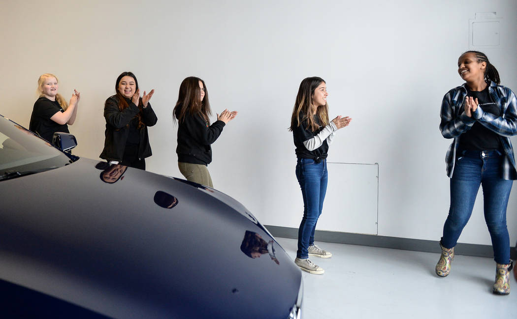 Middle school students dance to music they put on in one of the Tesla cars on display as Tesla celebrates "Introduce a Girl to Engineering Day" at its Sahara showroom in Las Vegas, Thursday, Feb. ...