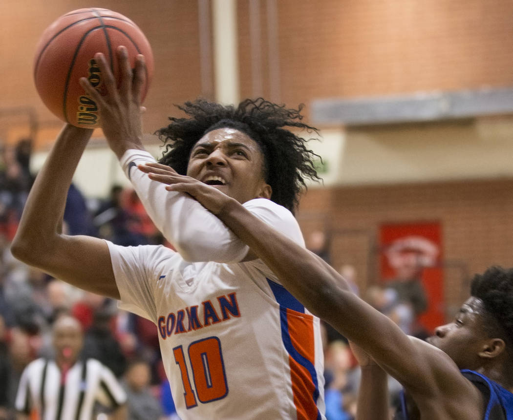 Bishop Gorman sophomore guard Zaon Collins (10) drives past Desert Pines sophomore Semaj Threats (1) in the second quarter during the Southern Nevada boys basketball championship game on Monday, F ...