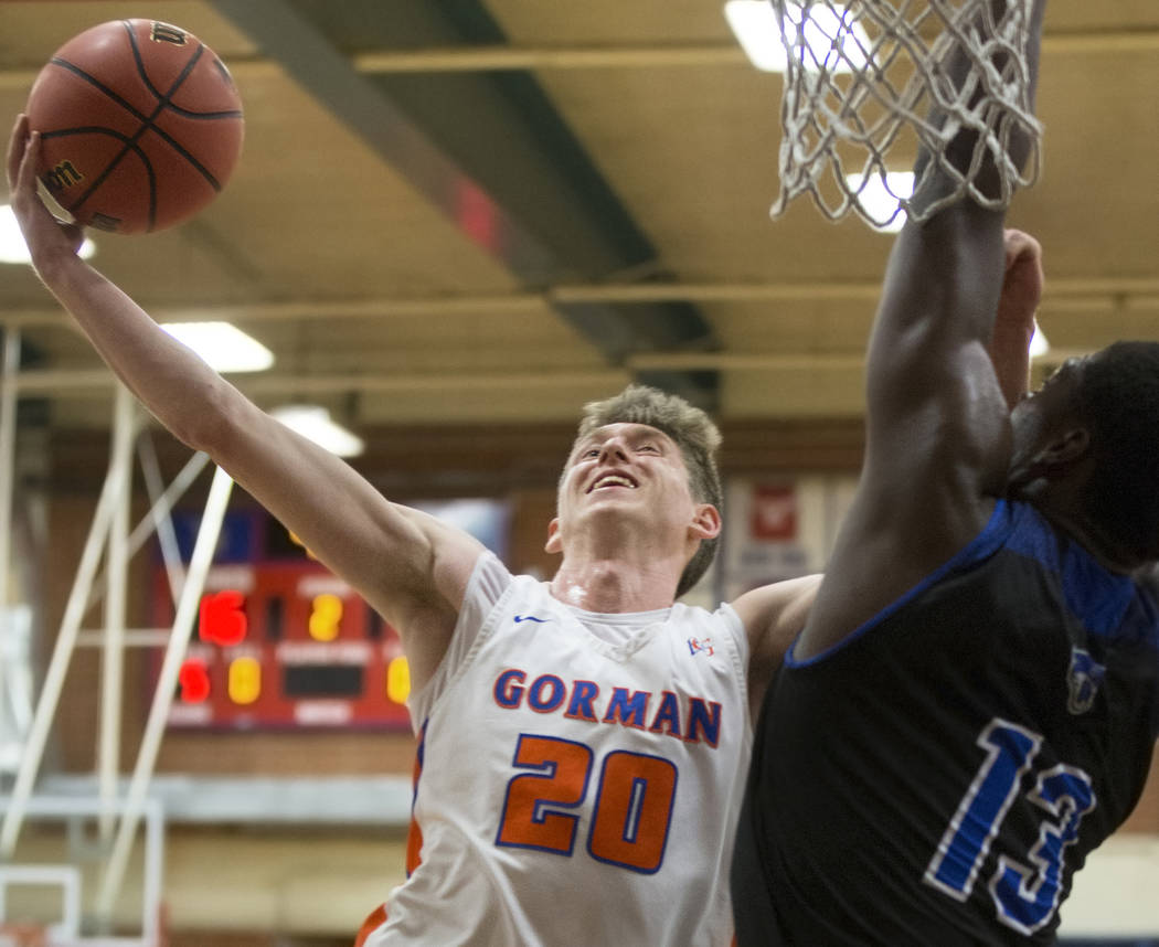 Bishop Gorman senior guard Noah Taitz (20) slices to the rim over Desert Pines junior Darnell Washington (13) in the second quarter during the Southern Nevada boys basketball championship game on ...