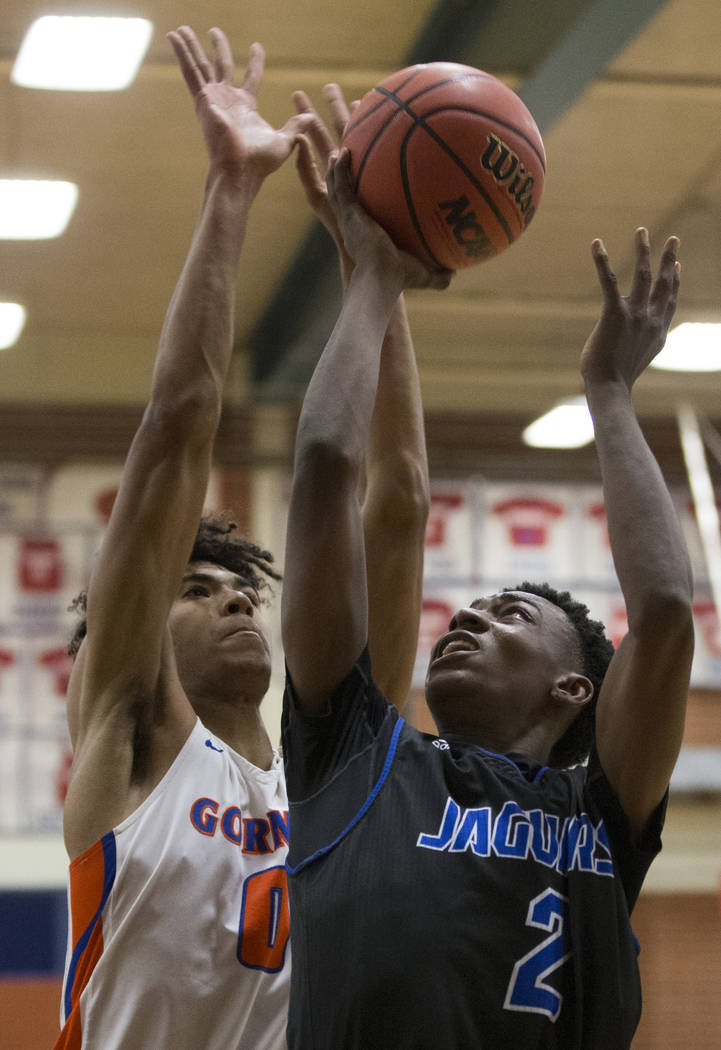 Desert Pines sophomore Dayshawn Wiley (2) grabs a rebound over Bishop Gorman junior forward Isaiah Cottrell (0) in the fourth quarter during the Southern Nevada boys basketball championship game o ...