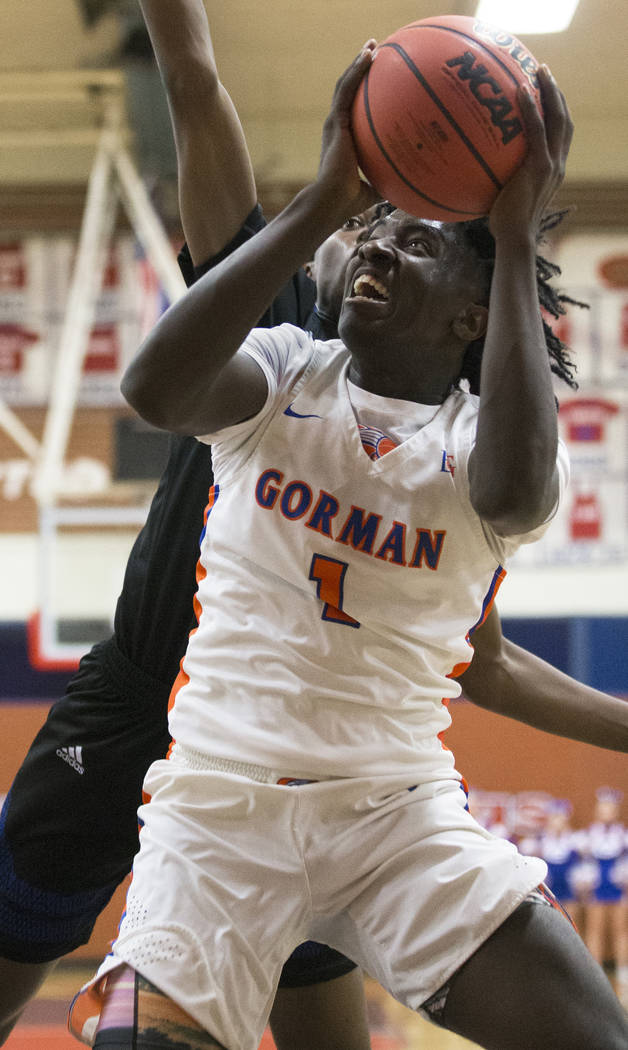 Bishop Gorman sophomore guard Will McClendon (1) drives baseline past Desert Pines sophomore Dayshawn Wiley (2) in the third quarter during the Southern Nevada boys basketball championship game on ...