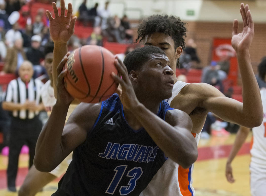 Desert Pines junior Darnell Washington (13) drives baseline past Bishop Gorman junior forward Isaiah Cottrell (0) in the fourth quarter during the Southern Nevada boys basketball championship game ...