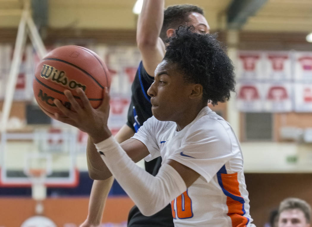 Bishop Gorman sophomore guard Zaon Collins (10) drives baseline past Desert Pines sophomore Cimarron Conriquez (3) in the third quarter during the Southern Nevada boys basketball championship game ...