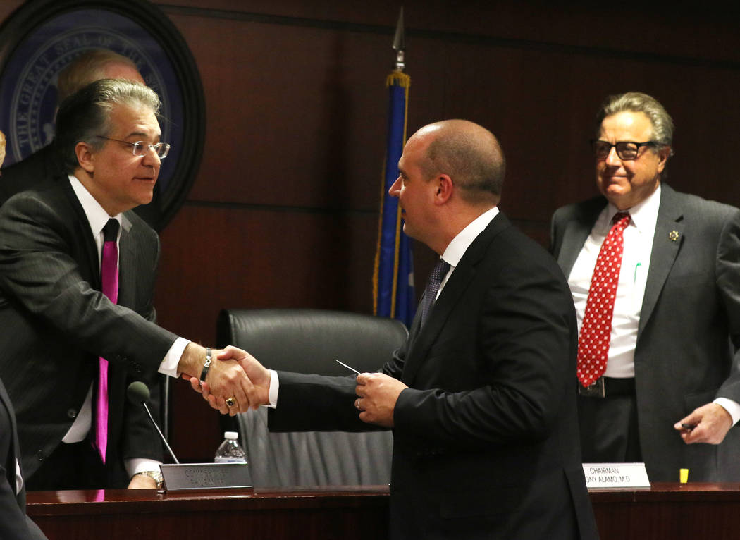 Dr. Tony Alamo, left, chairman of the Nevada Gaming Commission, shakes hands with Matt Maddox, CEO of Wynn Resorts Ltd., as Commissioner John T. Moran Jr., right looks on after a meeting of the Ne ...