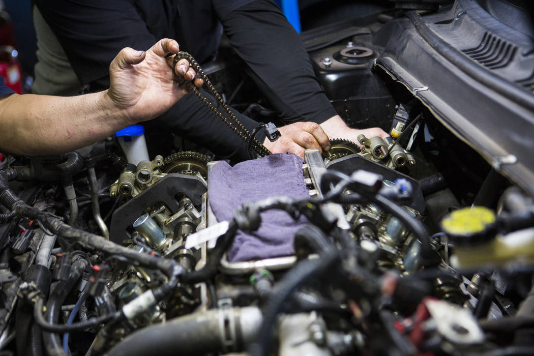 Paul Nakama, owner of Paul's Auto Service, left, helps assistant manager John Wright with a water pump change at the auto shopn in Las Vegas on Tuesday, Jan. 29, 2019. (Chase Stevens/Las Vegas Rev ...