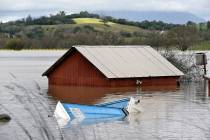A barn and farm equipment are seen submerged in flood waters from the Russian River in Forestville, north of San Francisco, Wednesday, Feb. 27, 2019. (AP Photo/Michael Short)