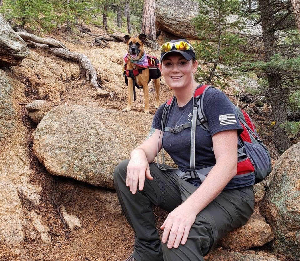 This undated photo provided by her wife Jessica Kibodeaux shows Lindsey Muller and her dog Emma hiking in the Cheyenne Mountains west of Fort Carson, Colo. (Jessica Kibodeaux via AP)