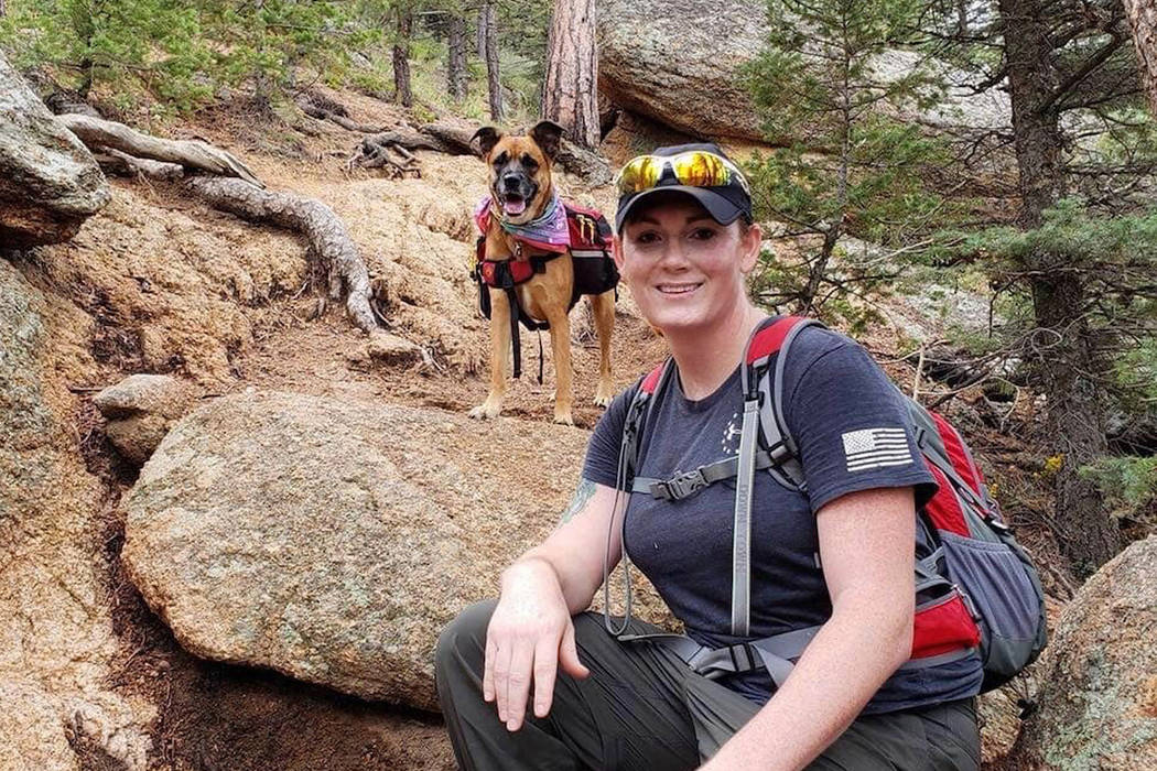 This undated photo provided by her wife Jessica Kibodeaux shows Lindsey Muller and her dog Emma hiking in the Cheyenne Mountains west of Fort Carson, Colo. (Jessica Kibodeaux via AP)