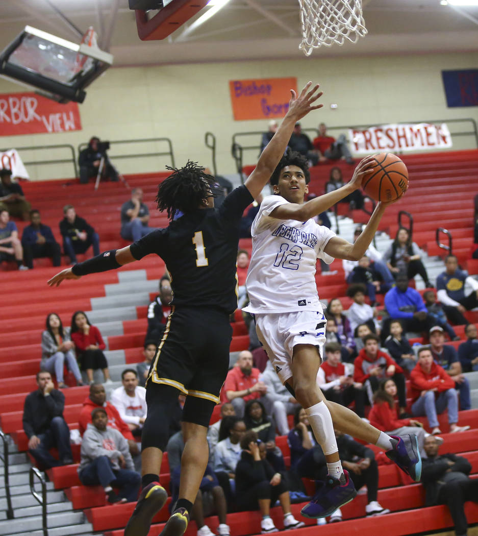 Desert Pines' Milos Uzan (12) goes to the basket against Clark's Frankie Collins (1) during the first half of a Class 4A state boys basketball quarterfinal game at Arbor View High School in Las Ve ...
