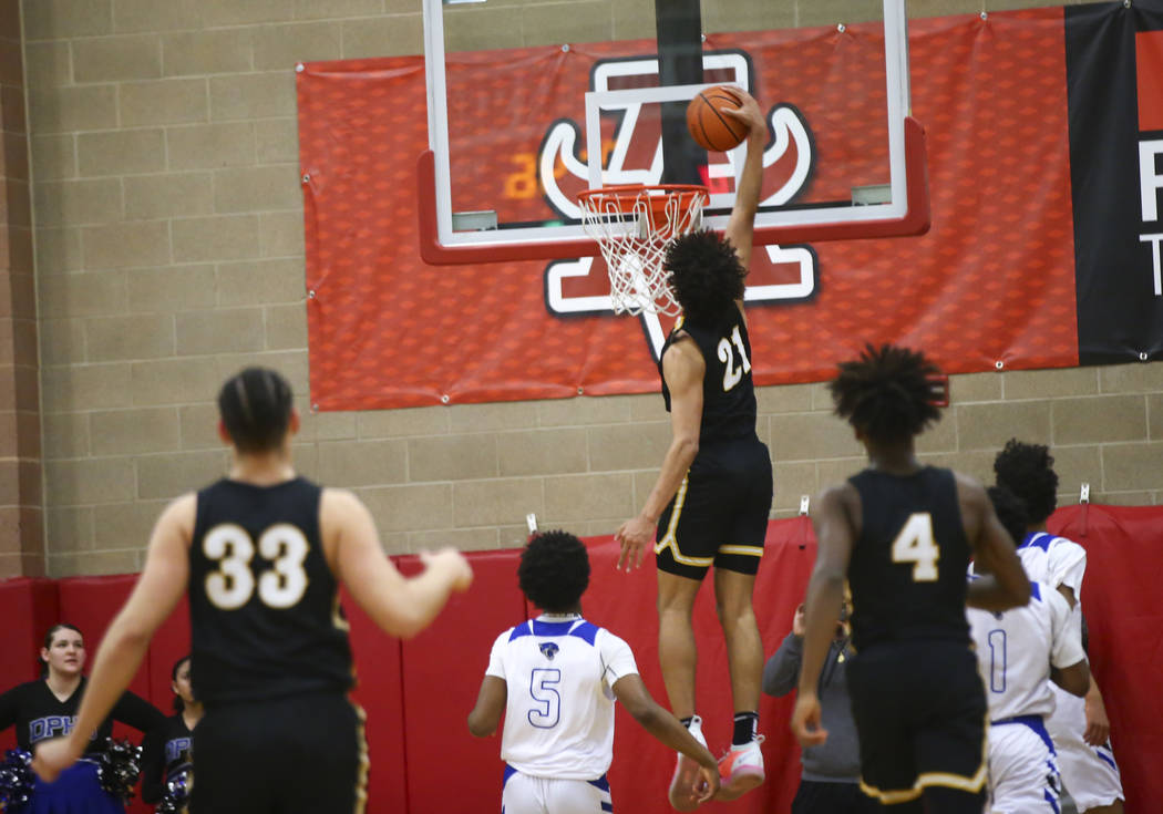 Clark's Jalen Hill (21) dunks in front of Desert Pines' Malik Brooks (5) during the first half of a Class 4A state boys basketball quarterfinal game at Arbor View High School in Las Vegas on Wedne ...