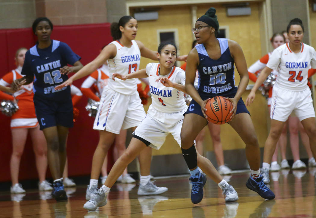 Canyon Springs' Sydnei Collier (10) moves the ball around Bishop Gorman's Caira Young (1) during the first half of a Class 4A state girls basketball quarterfinal game at Arbor View High School in ...