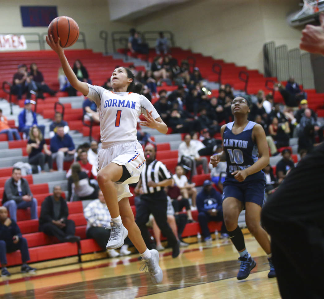 Bishop Gorman's Caira Young (1) goes to the basket past Canyon Springs' Sydnei Collier (10) during the first half of a Class 4A state girls basketball quarterfinal game at Arbor View High School i ...