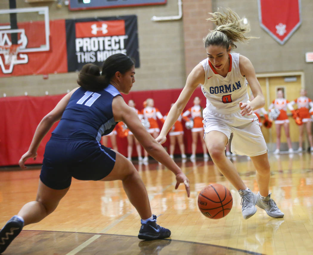 Bishop Gorman's Izzy Westbrook (0) and Canyon Springs' Jeanette Fine (11) chase after a loose ball during the first half of a Class 4A state girls basketball quarterfinal game at Arbor View High S ...