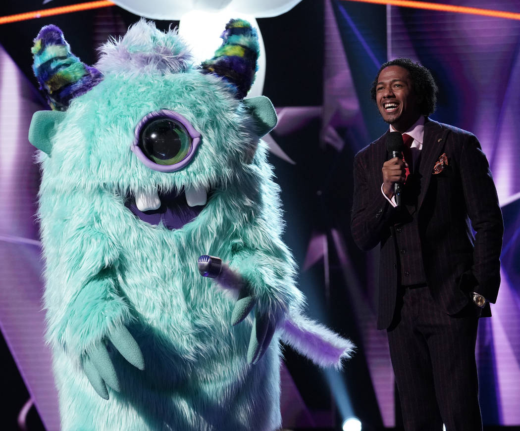 The Monster and host Nick Cannon are seen in "The Masked Singer." (Michael Becker/Fox)