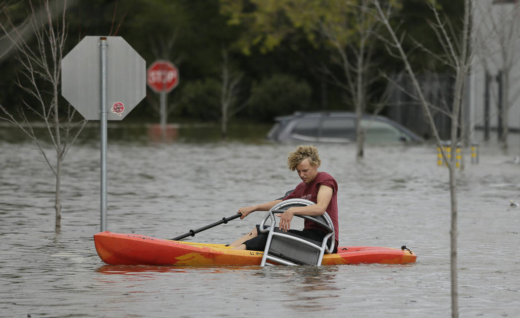 A man retrieves a chair floating in the parking lot of the Barlow Market District, Wednesday, Feb. 27, 2019, in Sebastopol, Calif. (Eric Risberg/AP)