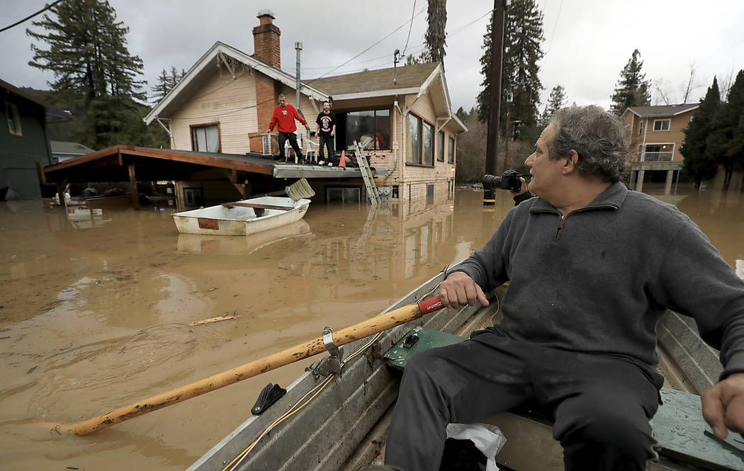 Jonathan Von Renner checks on his son Jonathan Jr., and friend Emilio Ontivares in lower Guerneville, Calif., Wednesday, Feb. 27, 2019. Two Northern California communities are accessible only by b ...