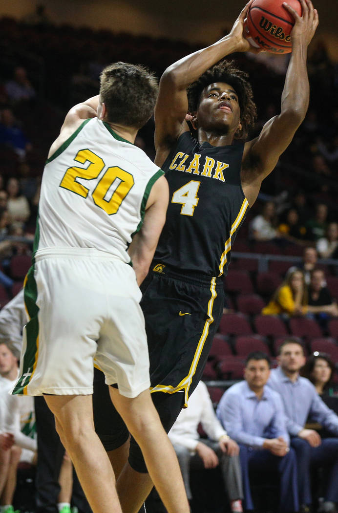 Clark's Carlos Allen (4) looks to take a shot while being guarded by Bishop Manogue's Cort Ballinger (20) during the first half of a Class 4A state boys basketball semifinal game at the Orleans Ar ...